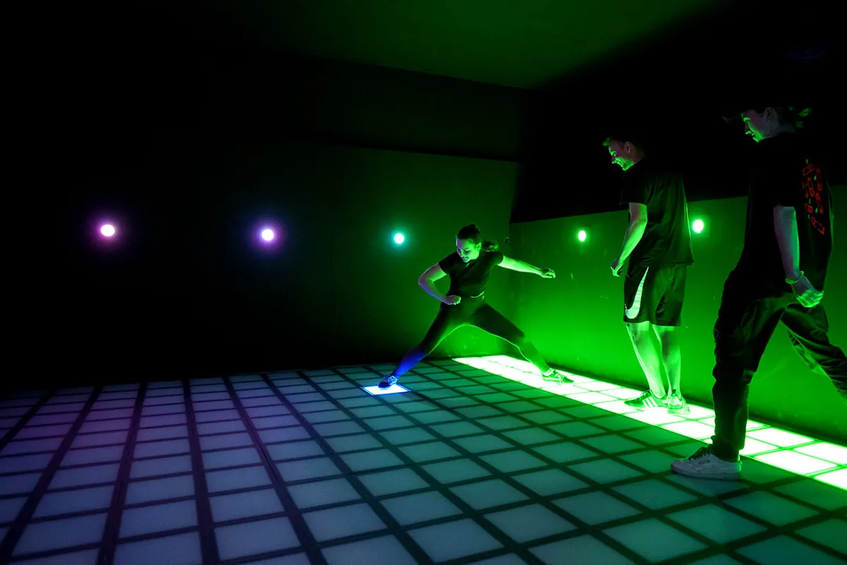 drei jugendliche stellen sich dem spielspass am leuchtenden fussboden der pixelzone