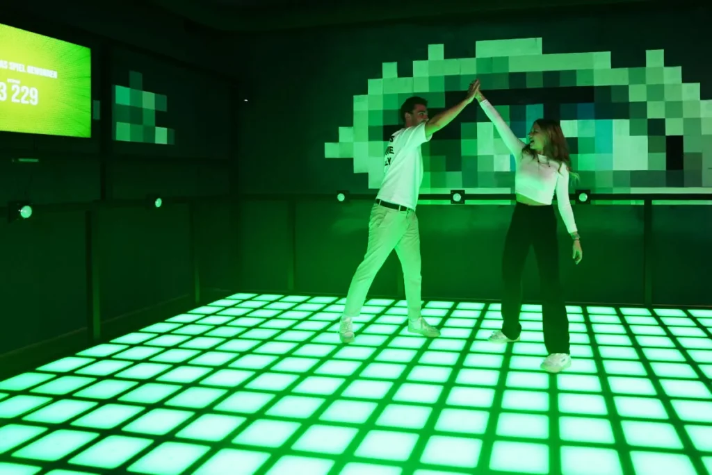 ein mann und eine frau spielen am gruenen PixelZone LED Fussboden