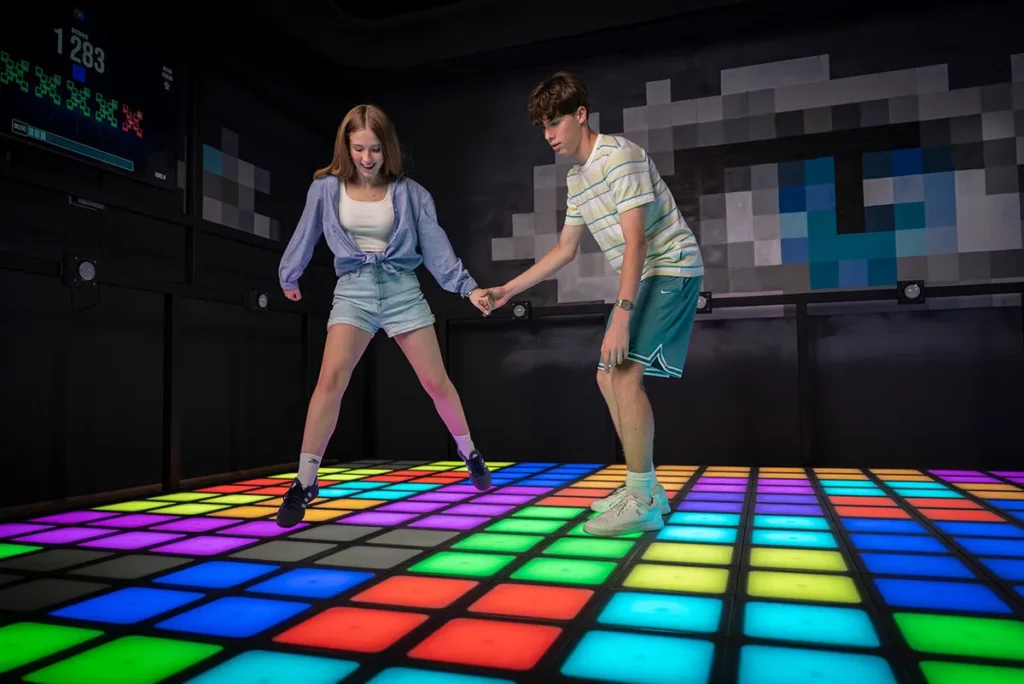 ein mann und eine frau spielen am gruenen PixelZone LED Fussboden